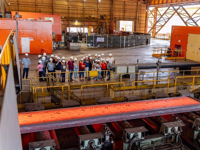 Visitantes em área industrial usando equipamentos de segurança